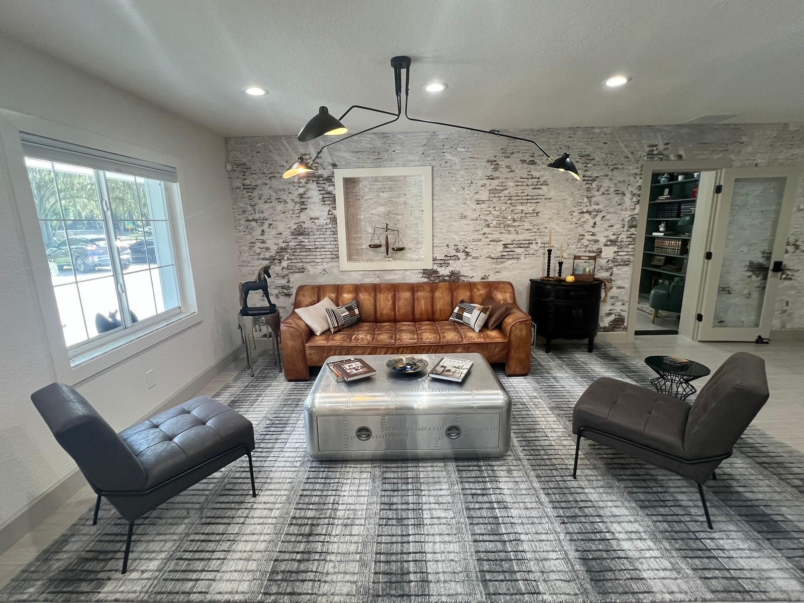 Contemporary living room with neutral tones, a sleek sofa, and elegant wooden staircase.